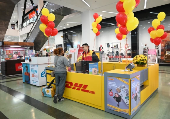 Activación de marca de DHL con stand decorado y atención personalizada en punto de alto tráfico, reforzando presencia y servicio.
